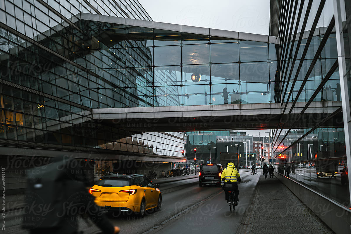 Street in Copenhagen, road between two glass buildings with bridge