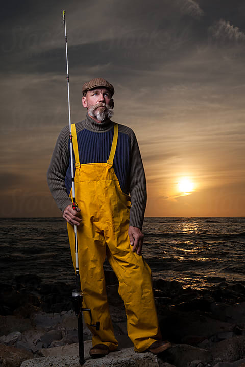 Fisherman Standing By The Sea At Dusk by Stocksy Contributor