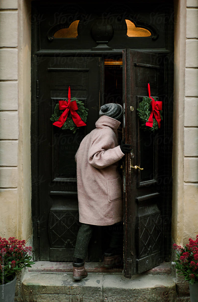 The girl enters the building through the Doors with Christmas decorations