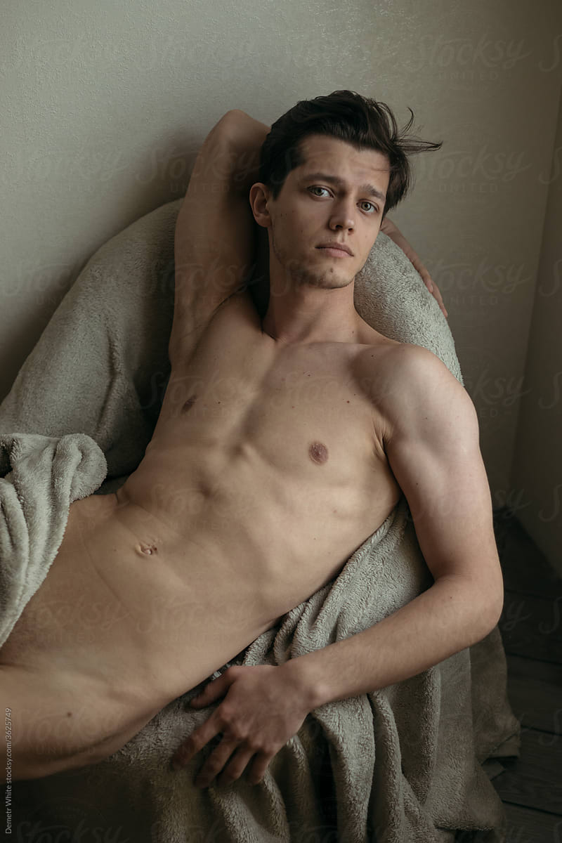 handsome man posing naked on the armchair