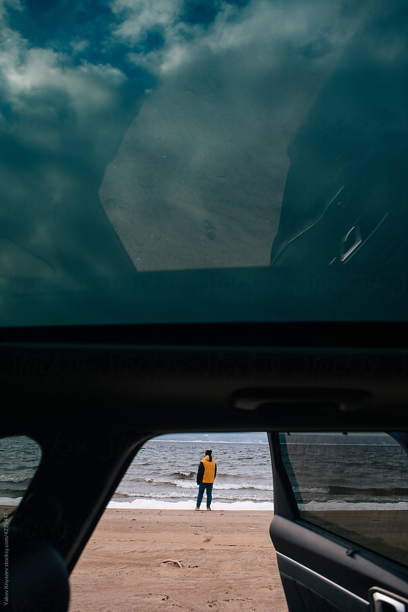 man in a yellow jacket watching at the sea