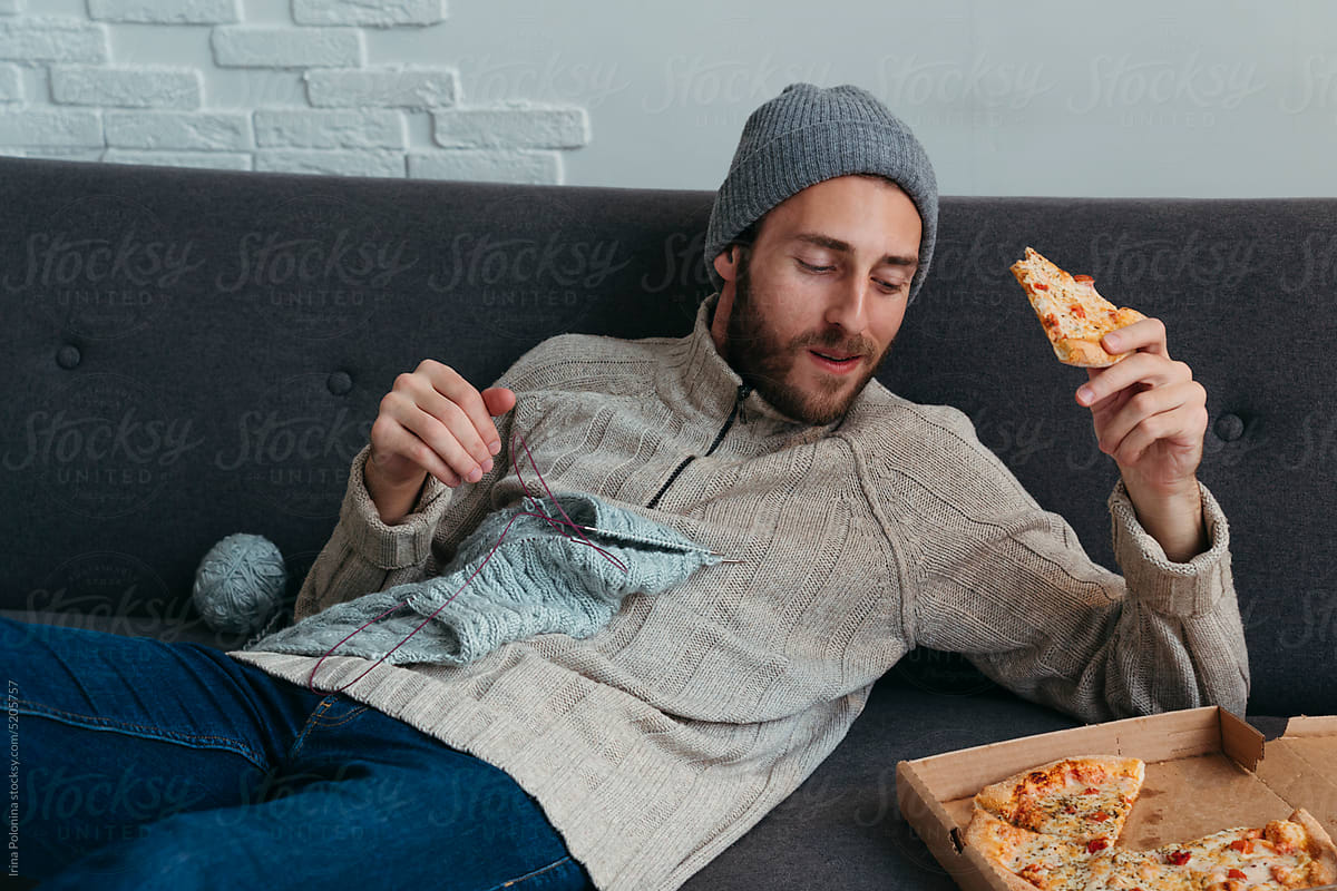Modern man eats pizza at cozy home.