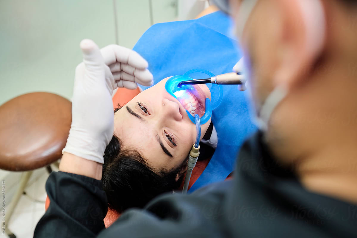 Dentist using a light curator in a patient\'s mouth