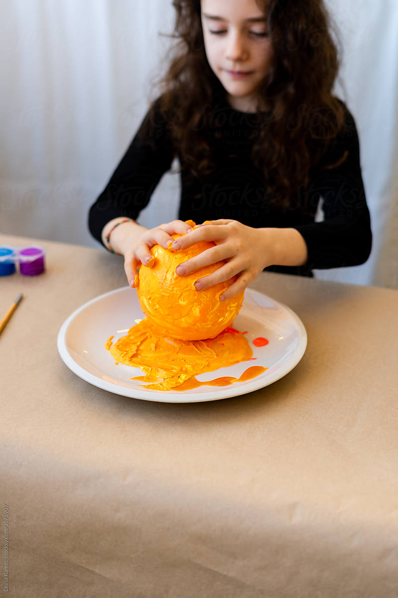 Girl painting the sun yellow with her hands for her science project