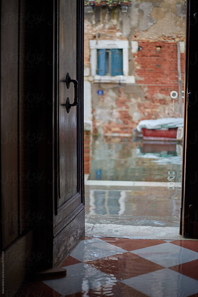 Canal overflows and flows into doorway, Venice
