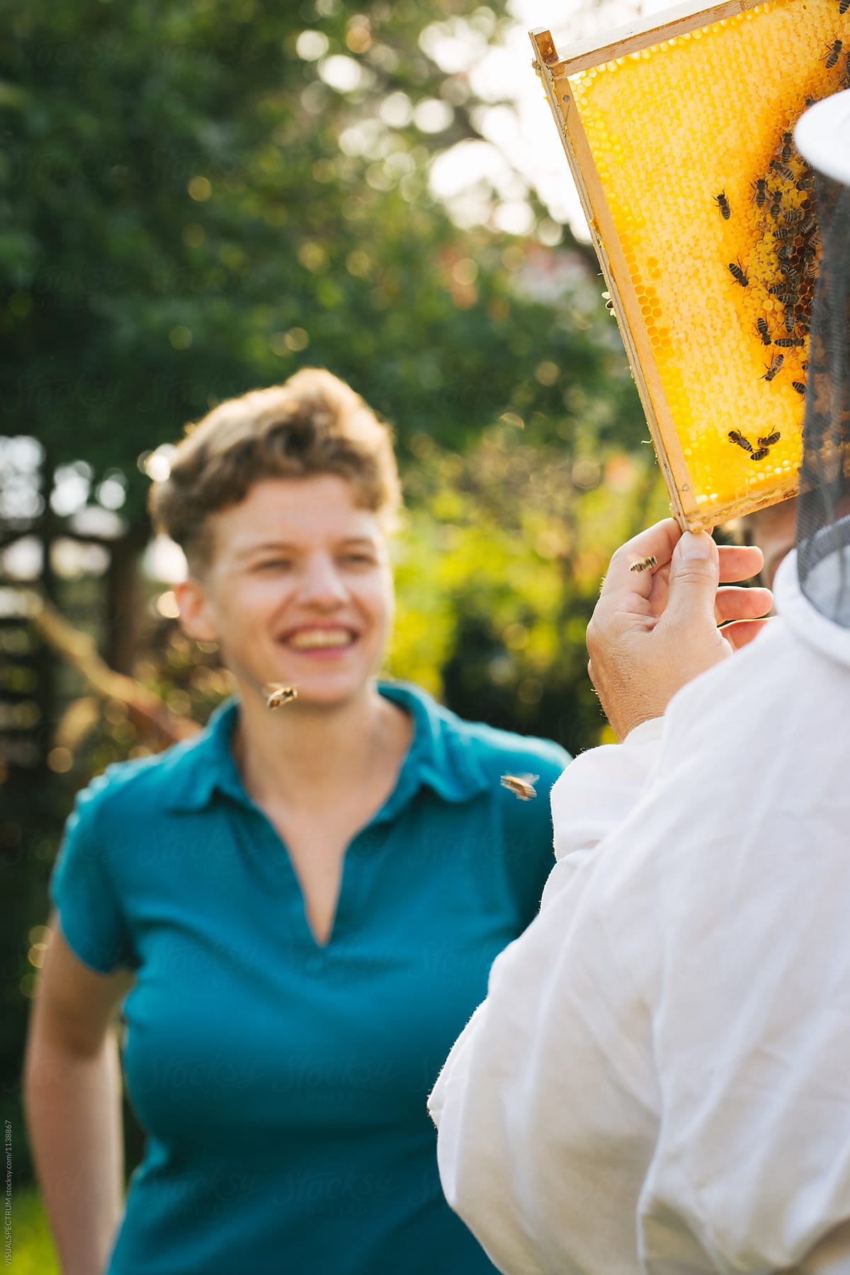 Female Beekeeping Student Smiling at Bee Frame
