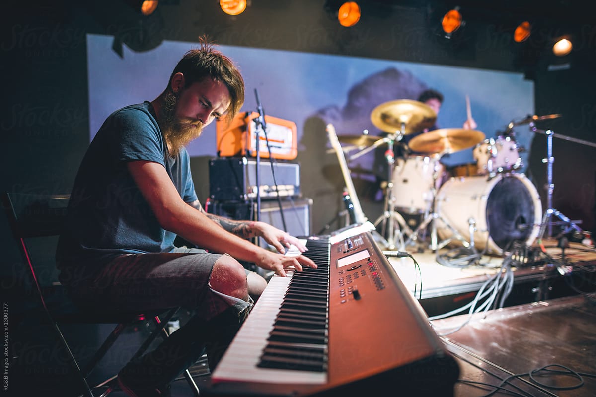 Bearded male musician playing on keyboards