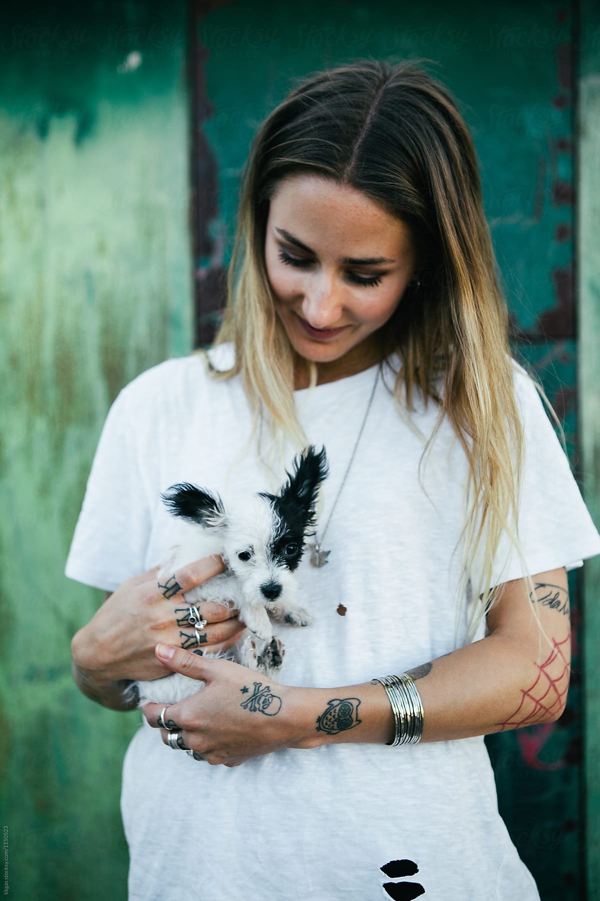 Beautiful tattooed woman cuddling a puppy