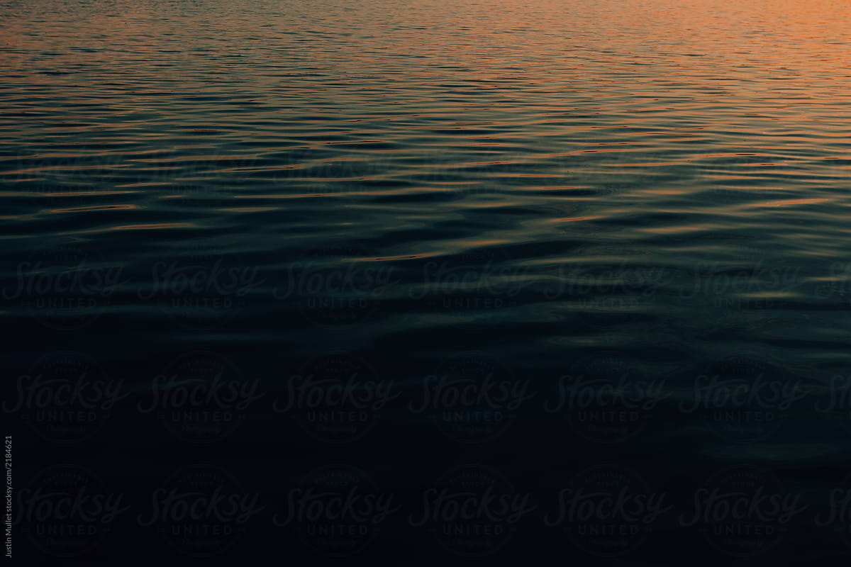Sunset hues reflected on water background.