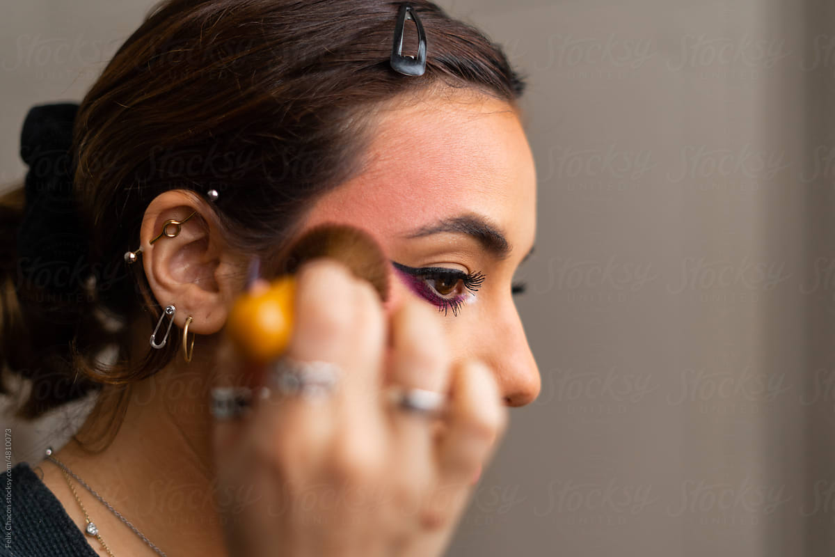 Young woman applying contour.