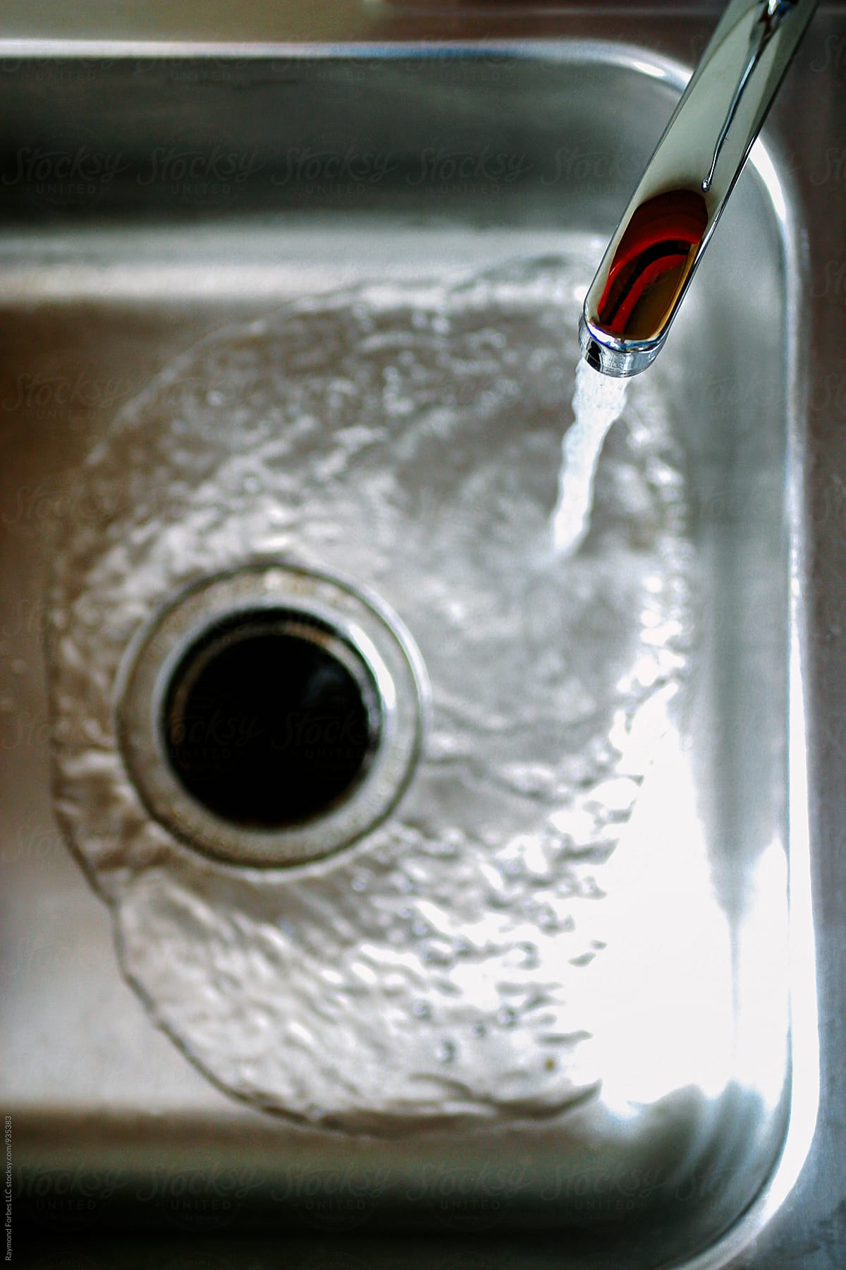 Down the Drain in sink with water running