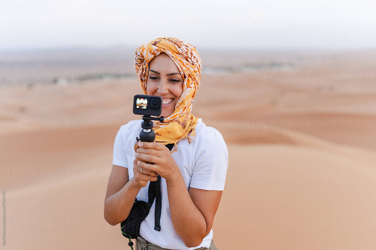 Hijab woman with camera in the middle of the desert.