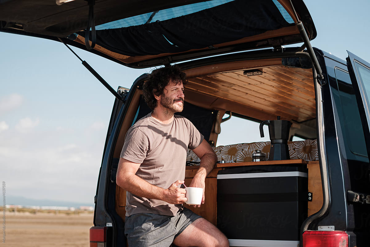 Man have a coffee in camper van