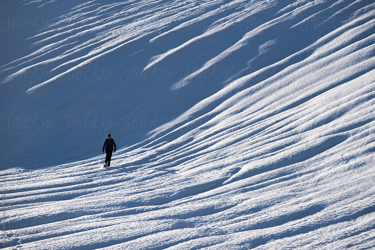 silhouette of person walking in snow
