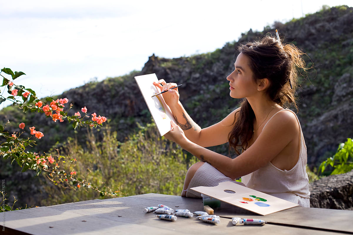 young woman making watercolor painting outdoors