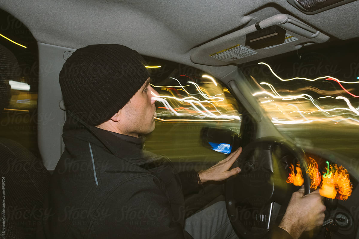 Man Driving at Night in City Lights
