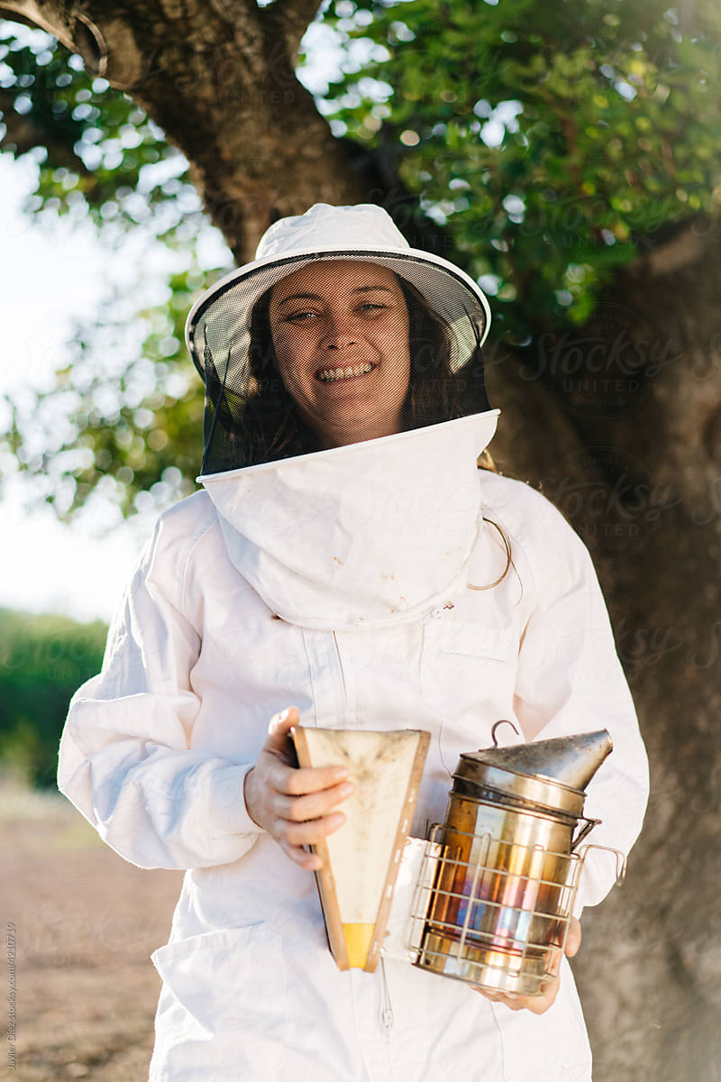 Cheerful female beekeeper on apiary