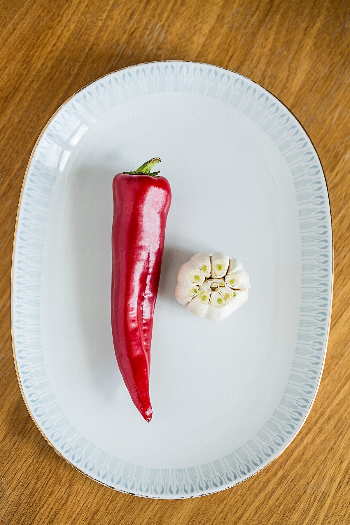 fresh red pepper and garlic bulb on vintage plate