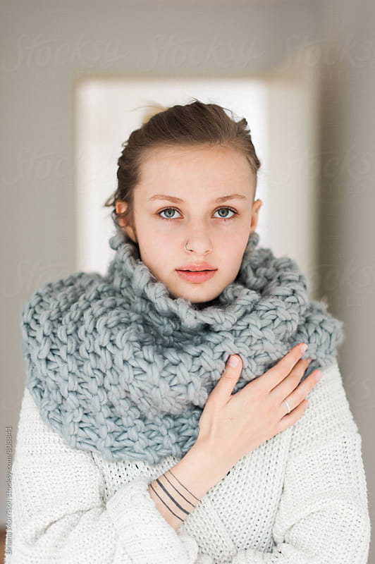 Young Fashionable Woman Wearing a Warm Scarf and Sweater Indoors