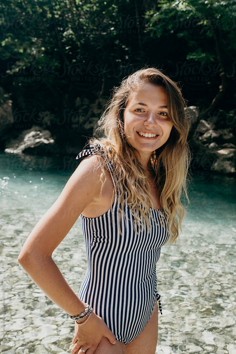 Teenager girl wearing bikini stands in the water of a beautiful