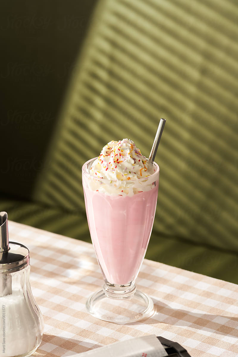 Strawberry milkshake in glass on table