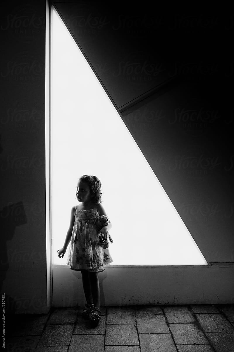 Kid in backlight over white triangle shaped lighted background