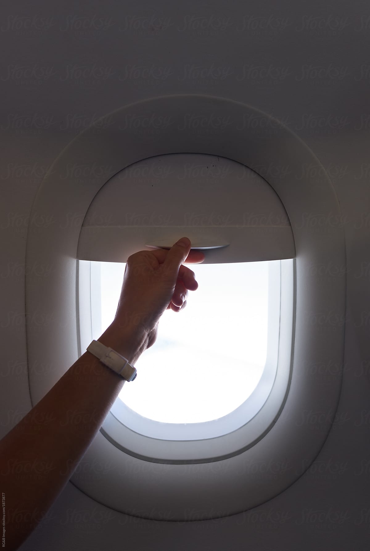 Woman\'s hand beside airplane window