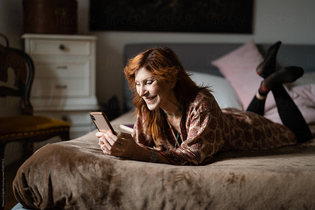 Woman use her smartphone on the bed at home
