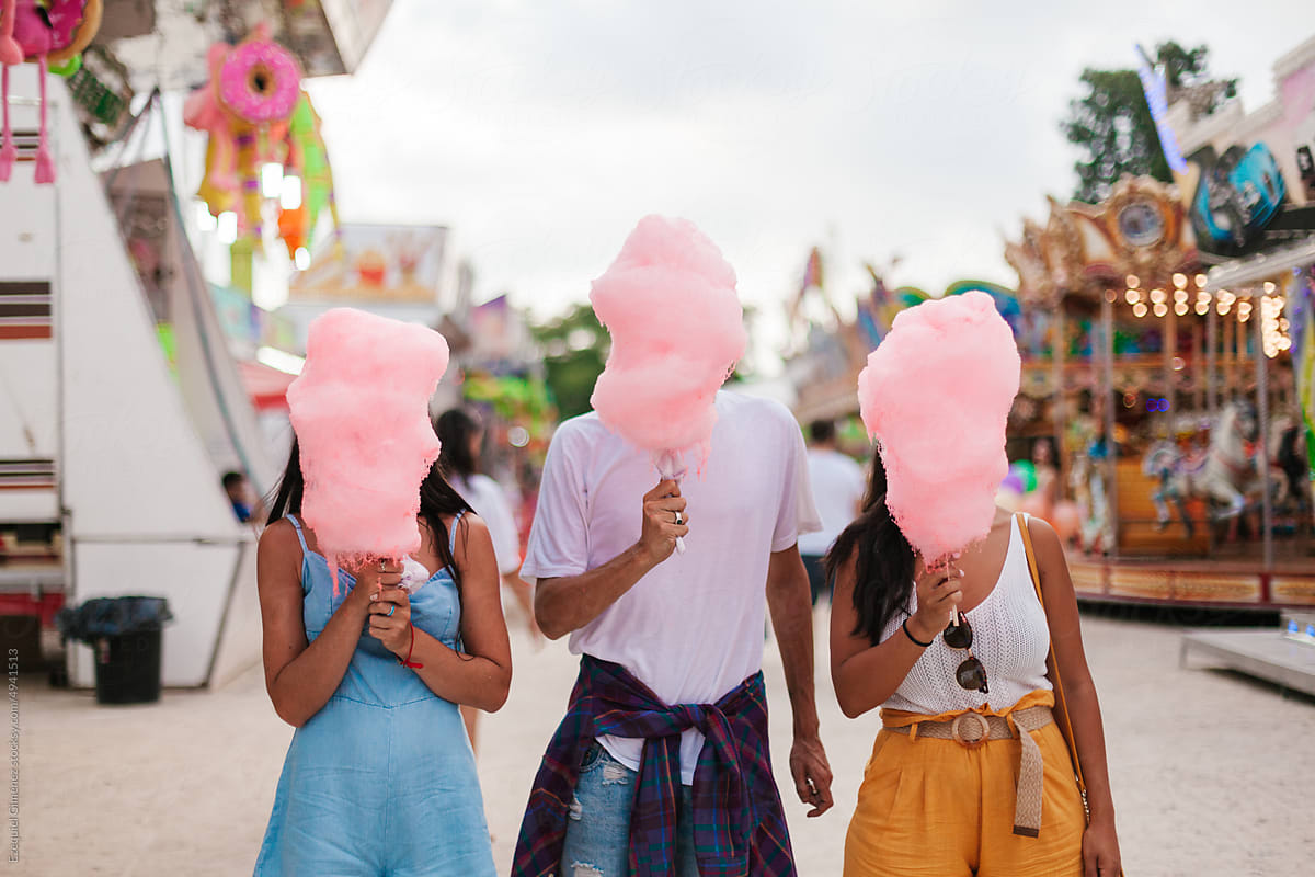 Unrecognisable people eating candyfloss at the fair