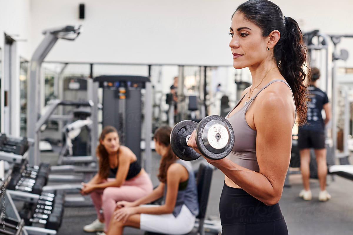 Woman lifting dumbbells in a gym