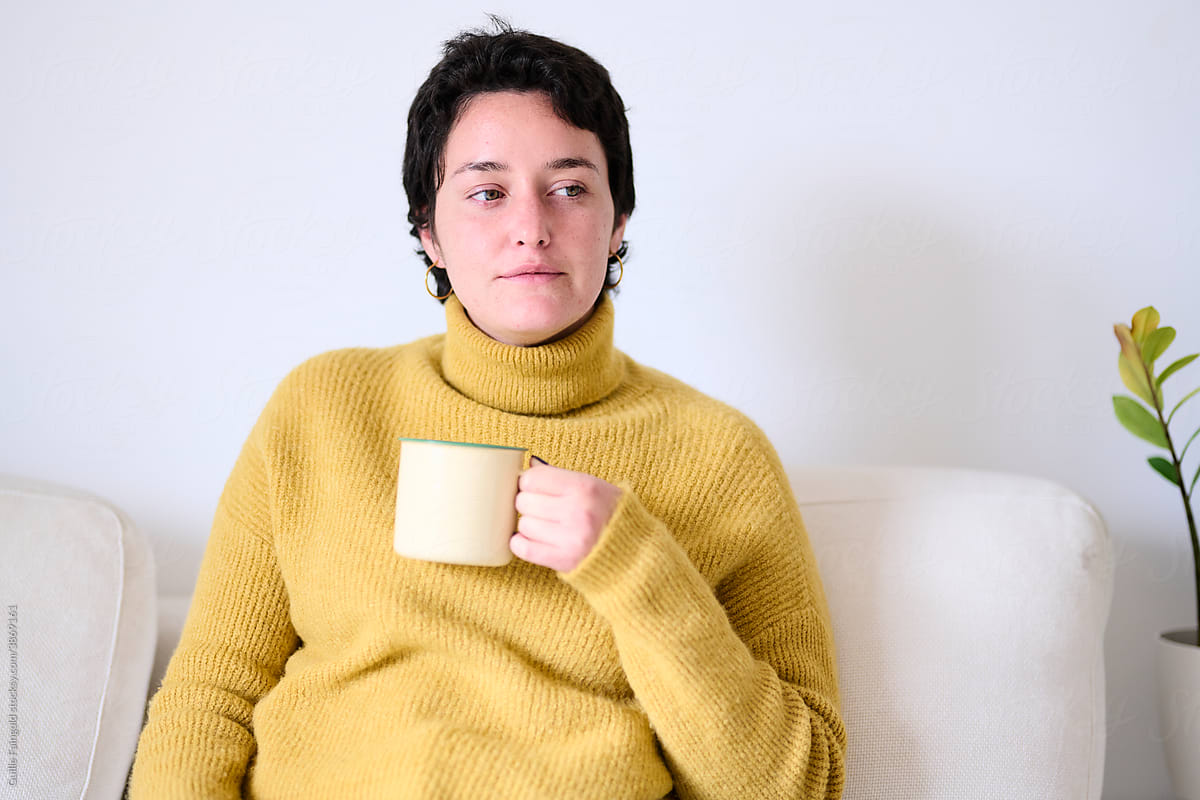 Relaxed brunette in sweater with hot drink