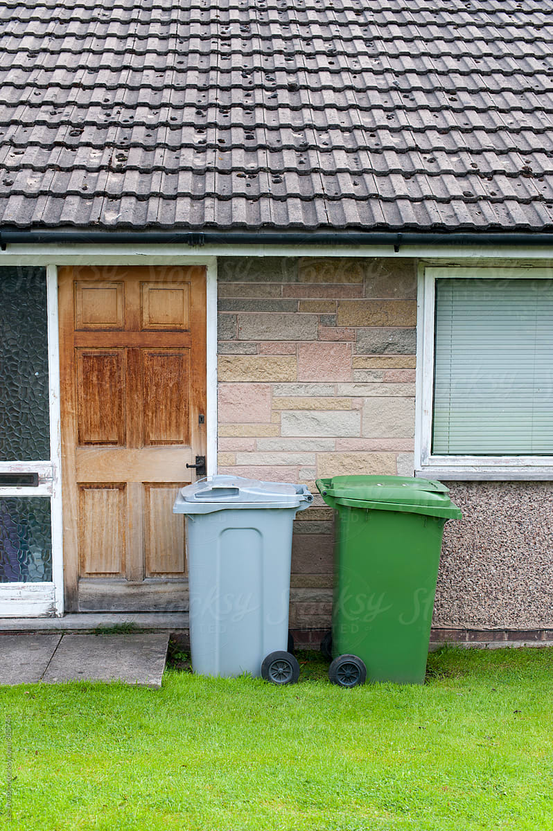 garbage, recycling or rubbish bins outside a house