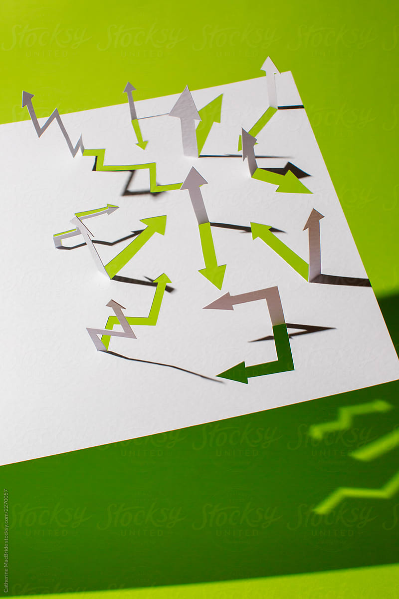 Paper craft arrows pointing every direction on a rich green background