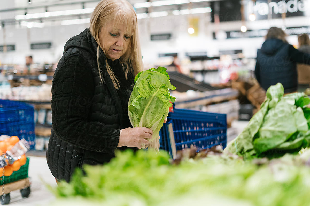 Woman choosing lettuce in supermarket