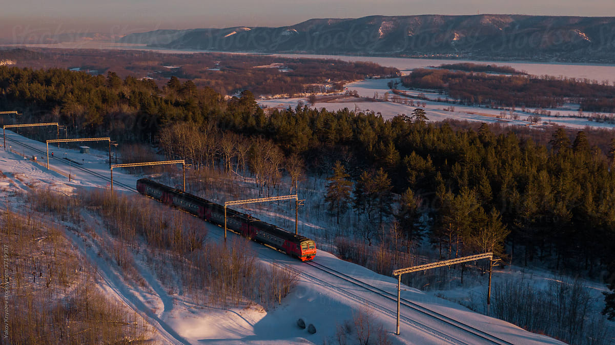 train passing by a winter forest