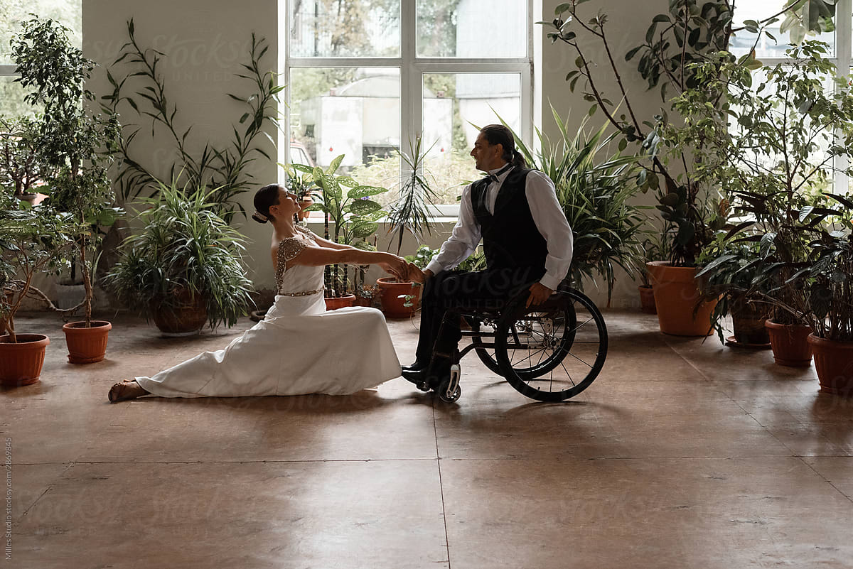 Couple practicing wheelchair dance amidst plants