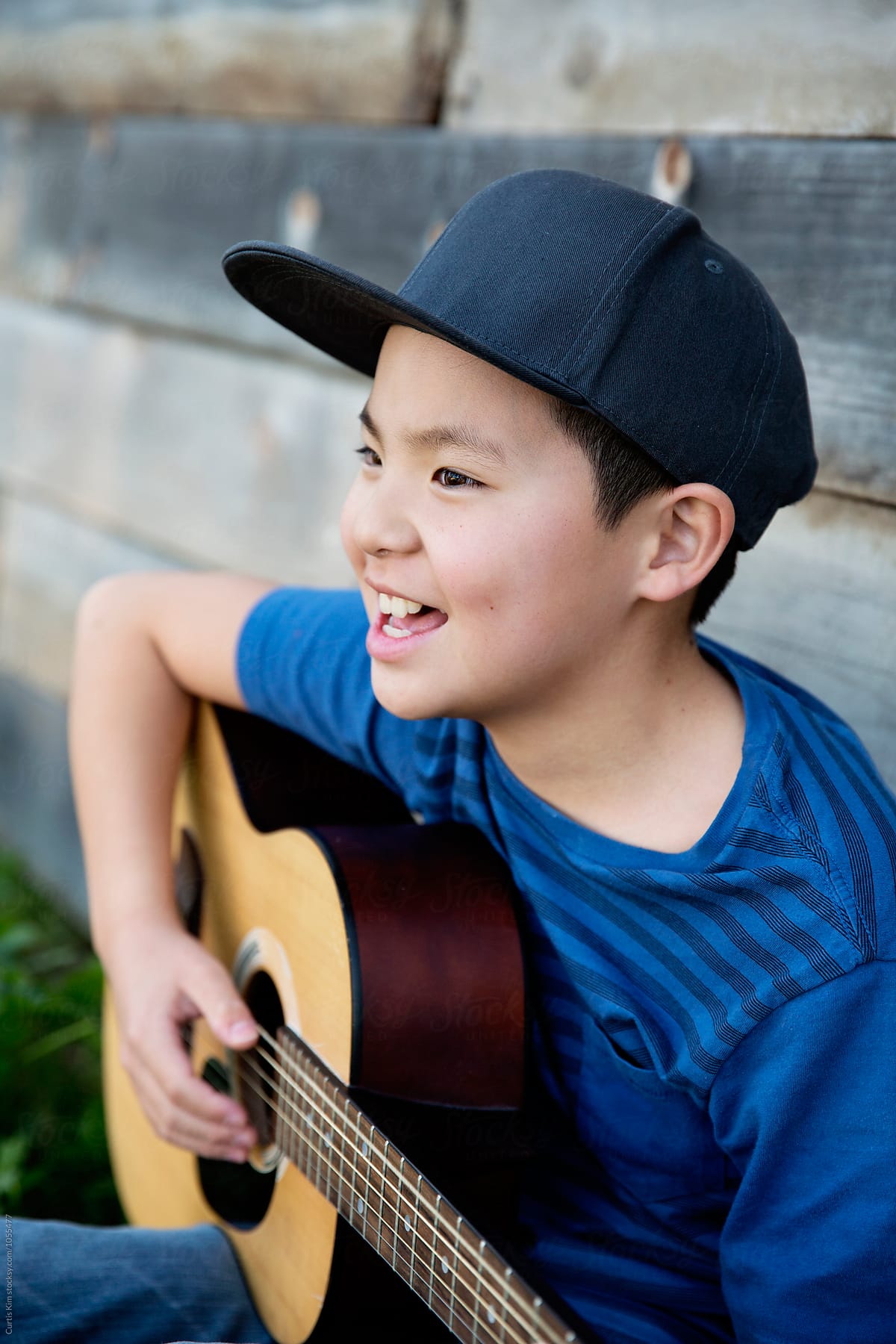 Asian boy singing and playing his guitar