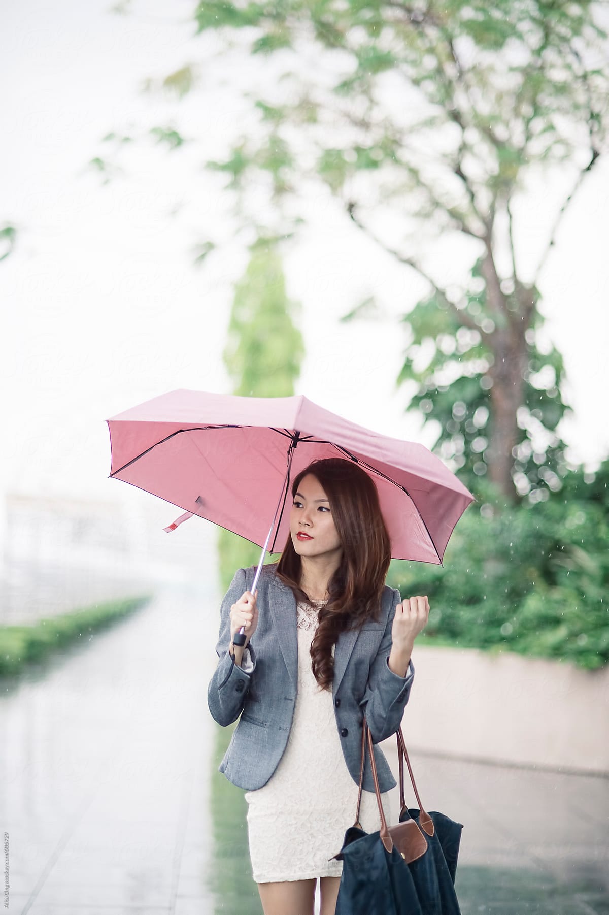 Beautiful woman holding umbrella in rainy day
