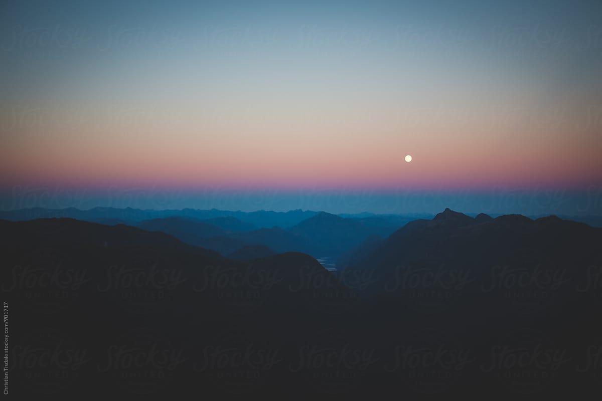 View of the moon from a mountain peak at sunset