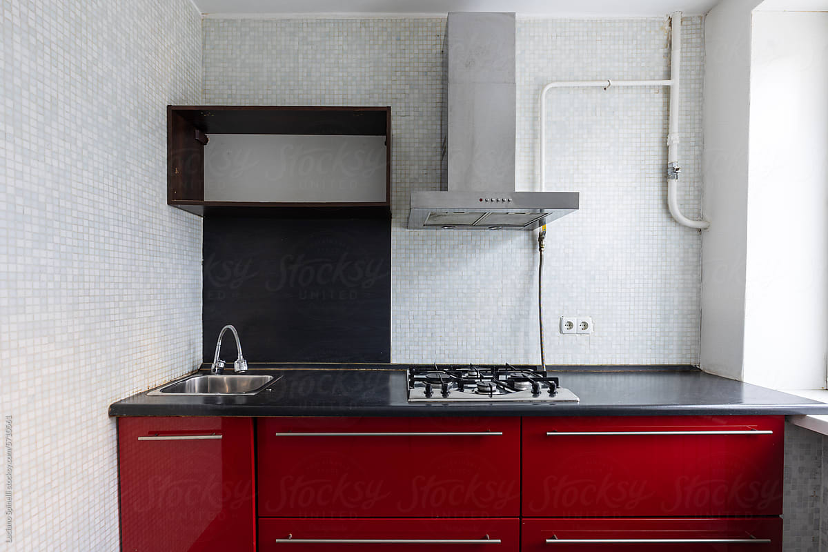 Front view of red and black modern kitchen cabinetry in empty studio