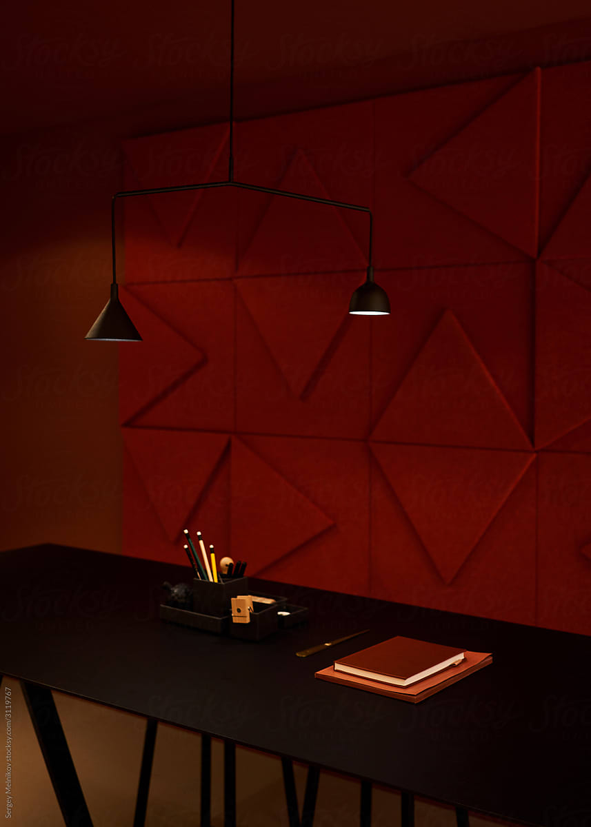 Table and chairs near geometric wall