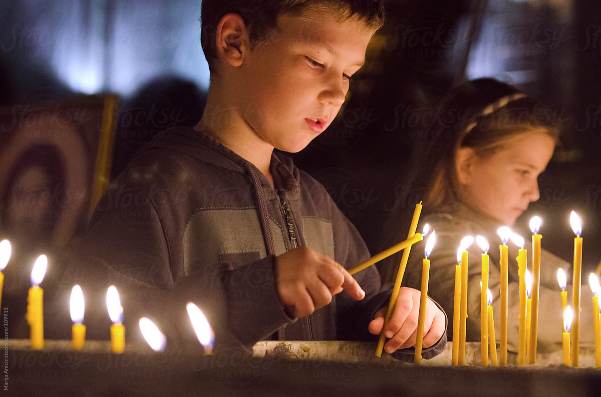Boy and girl lighting candles in Church