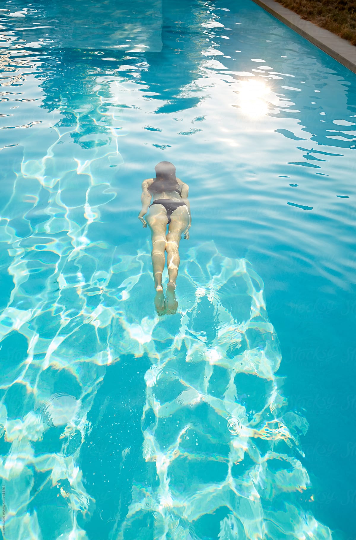 Woman floating in water in swimming pool