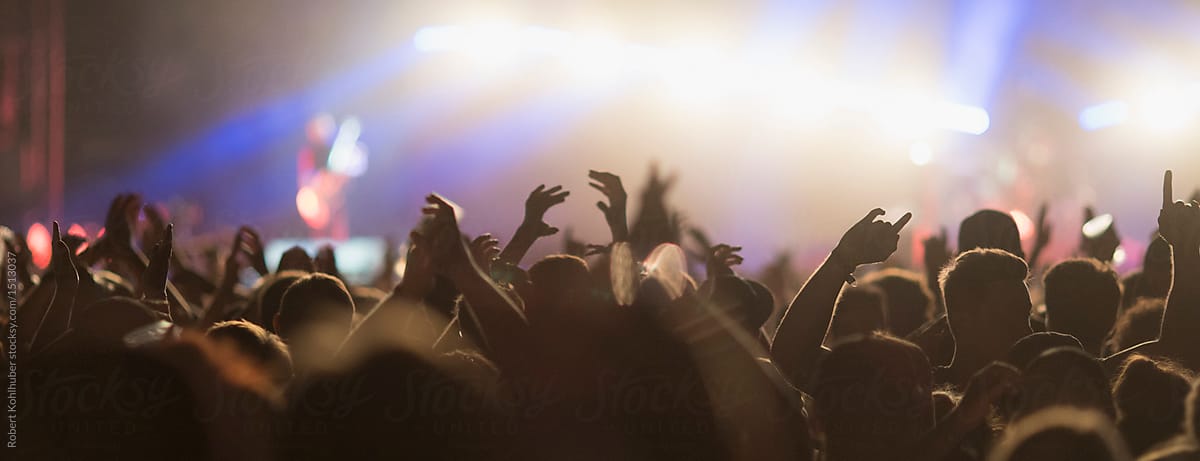 Sillhouettes of concert crowd in front of bright stage lights