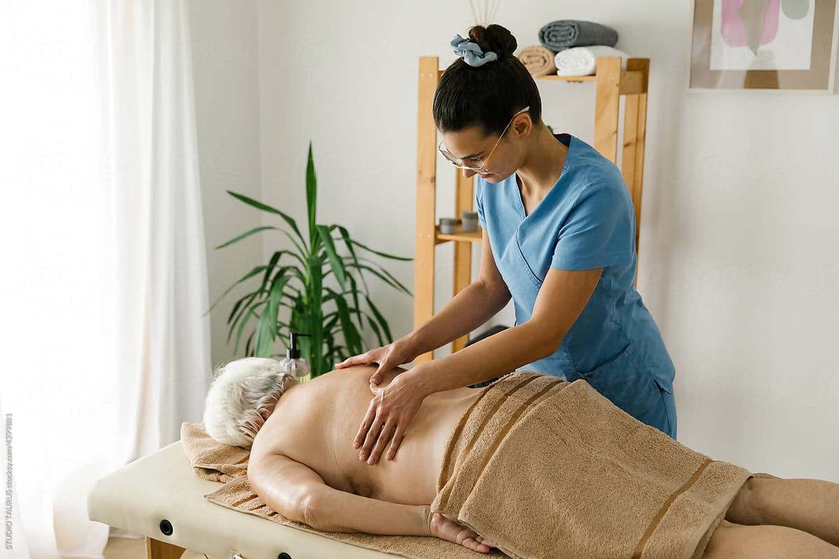 Boomer female having professional massage at spa