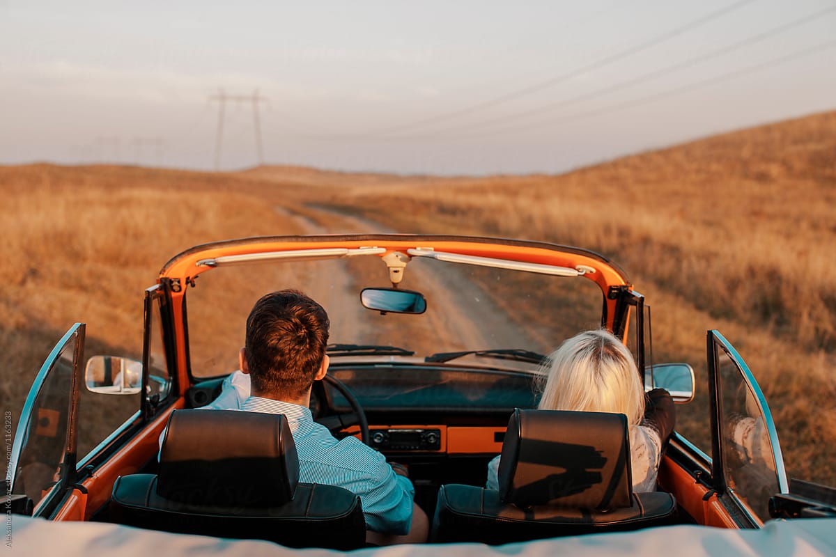 Couple in convertible car on road trip in nature
