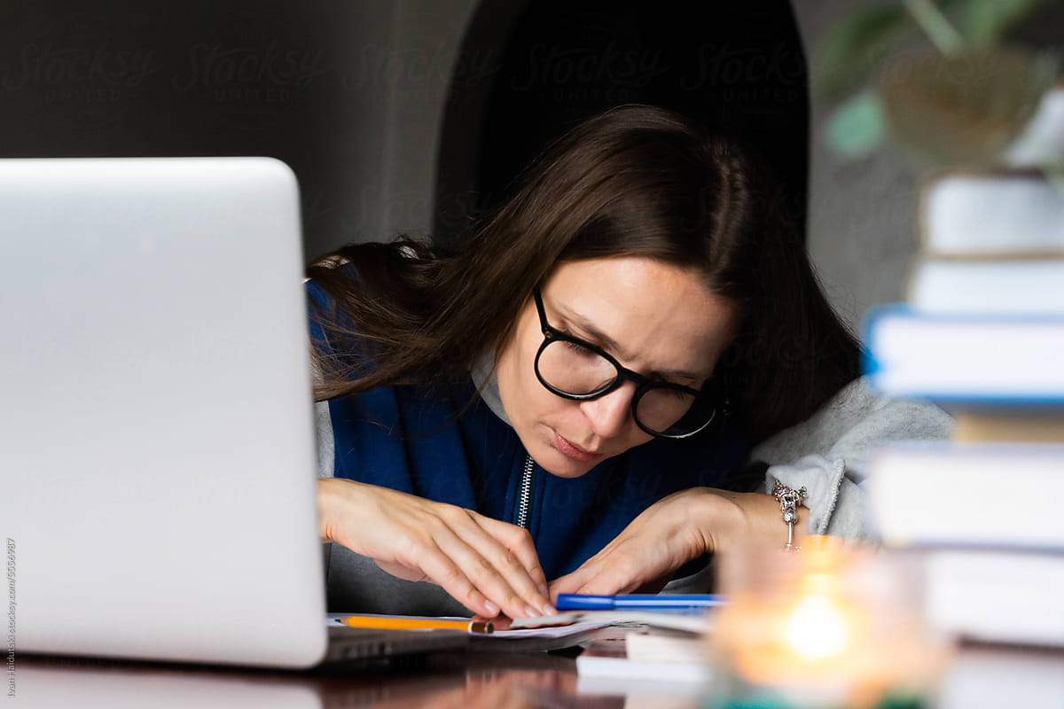 Focused college student taking notes study online on laptop