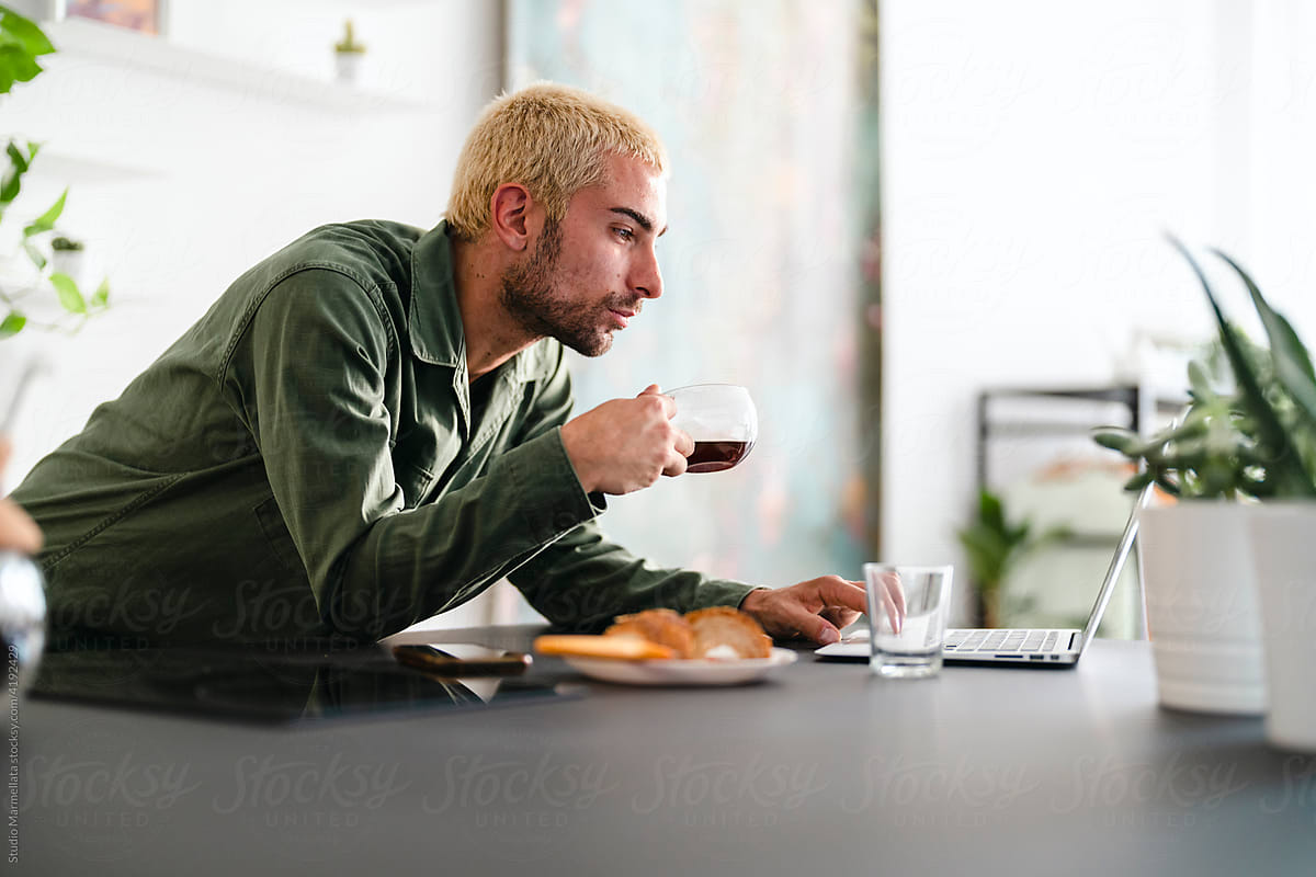 Man with coffee using laptop