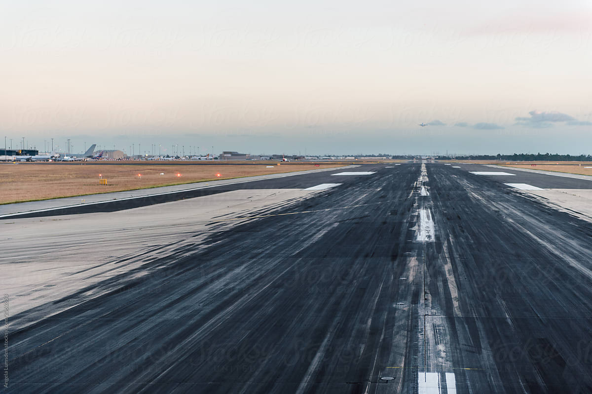 Looking down the line of an airport runway at dusk