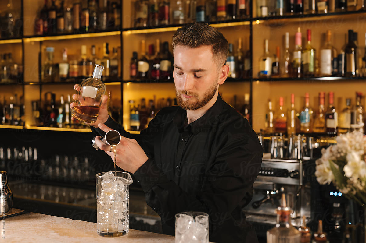 Barman pouring gin into glass